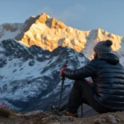 A trekker watching the sunrise on Mount Kanchenjunga from the Goechala Trek, a stunning high-altitude trek in Sikkim.