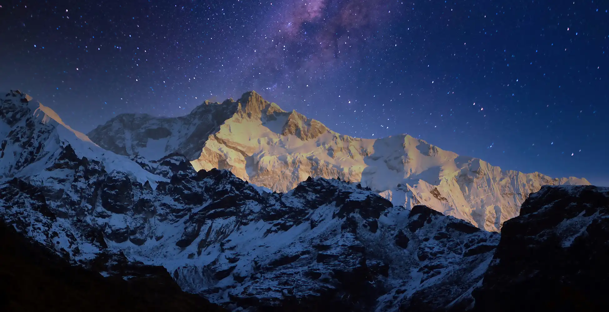 Breathtaking night view of Mt. Kanchenjunga illuminated under starlit skies as seen from Dzongri Top on the Goechala Trek in Sikkim.