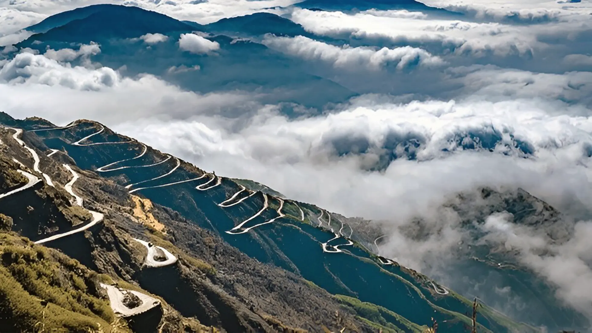 Winding Zuluk Loops road in East Sikkim, India, with mountains disappearing into a sea of clouds