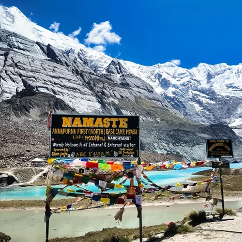 Colorful prayer flags at Panchakunda Lake marking Annapurna First North Base Camp, a route on the Annapurna Base Camp trek.