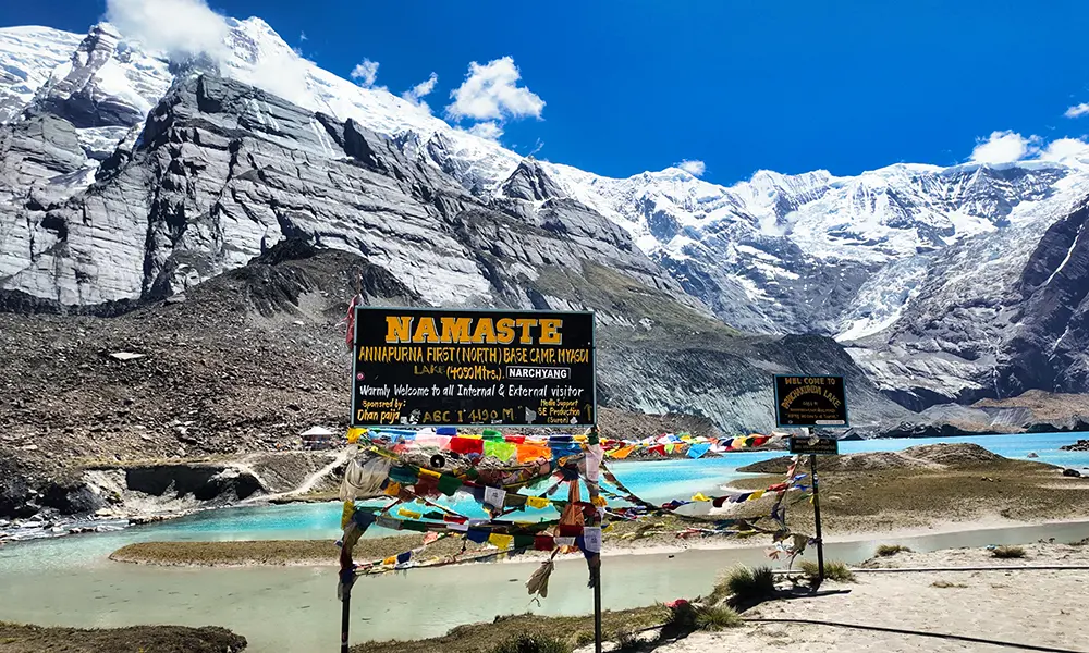 Colorful prayer flags at Panchakunda Lake marking Annapurna First North Base Camp, a route on the Annapurna Base Camp trek.