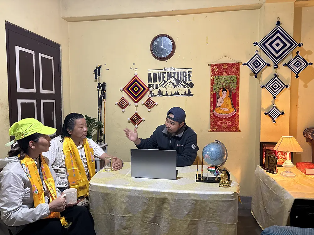 A Go Wild Expedition representative consulting with two tourists at their registered local office in Sikkim.