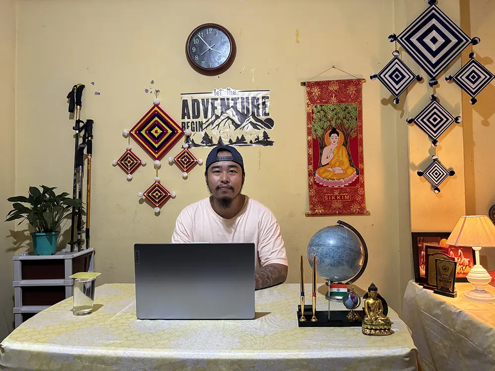 D.B. Khewa, founder and managing director of Go Wild Expedition, sitting at his office desk with a laptop.