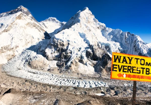 Yellow sign marking the way to Mt. Everest B.C. in Nepal, overlooking Khumbu Glacier and Mount Everest.